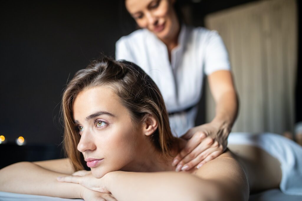 Young and healthy woman in spa salon. Traditional Swedish massage therapy